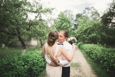 beautiful wedding couple in park. kiss and hug each other.の写真素材