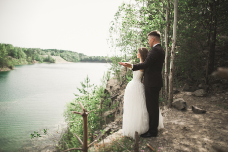 Wedding couple in love kissing and hugging near rocks on beautiful landscape.の写真素材