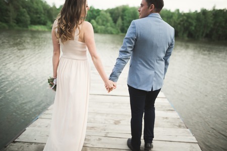 Wedding couple, bride, groom walking and posing on pier.の写真素材