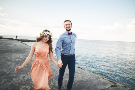 Wedding couple, bride, groom walking and posing on pier.の写真素材