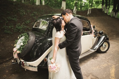 Beautiful wedding couple posing near splendid retro car.の写真素材