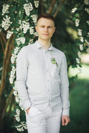 Man, groom posing in park on his wedding day.の写真素材