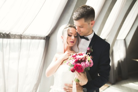 Perfect couple bride, groom posing and kissing in their wedding day.の写真素材