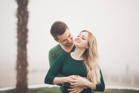 Lovely couple kissing and hugging on a sea dock.