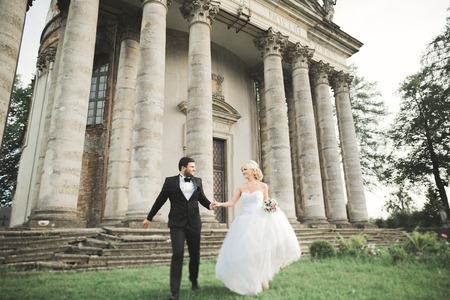 Beautiful romantic wedding couple of newlyweds hugging near old castle.の写真素材
