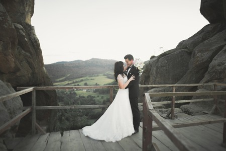 Wedding couple in love kissing and hugging near rocks on beautiful landscape.の写真素材