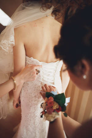 Luxury bride in white dress posing while preparing for the wedding ceremony.の写真素材