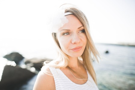 Romantic beautiful bride in white dress posing on the sea stones.の写真素材