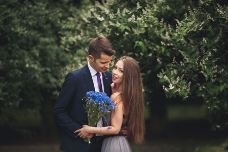 A young beautiful couple, girl with perfect dress posing in park.の写真素材