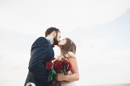 Married wedding couple standing on a wharf over the sea.の写真素材