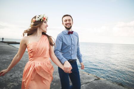 Wedding couple, bride, groom walking and posing on pier.の写真素材