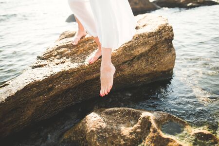 portrait of young woman posing near sea, wearing a dress.の写真素材