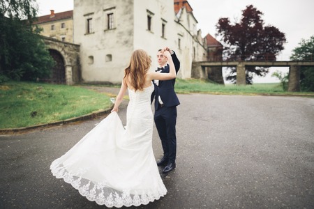 Happy wedding couple hugging and smiling each other on background old castle.
