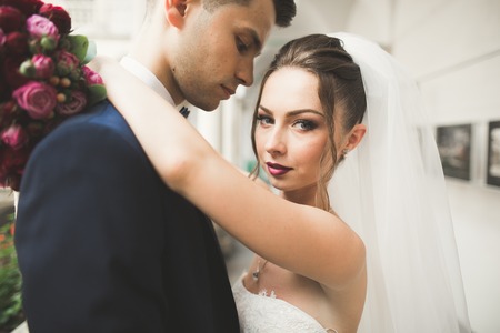 Portrait of happy newly wedding couple with bouquet.