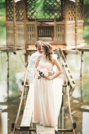 wedding pair hugging and kissing at the bridge.の写真素材
