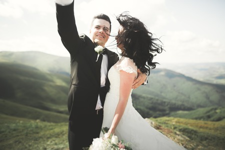 Beautiful young wedding couple making selfie on the background of mountains.の写真素材