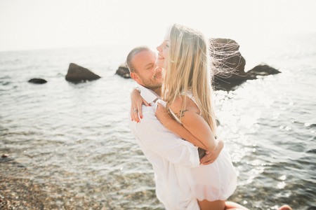 Happy romantic fashion couple in love have fun on beautiful sea at summer day.の写真素材