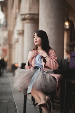 Beautiful Asian girl model in dress sitting at the old city background.の写真素材