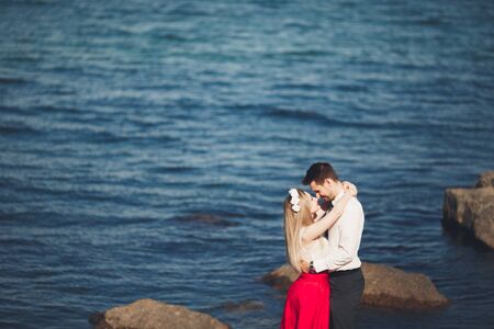 Charming bride and elegant groom on landscapes of mountains and sea Gorgeous wedding couple.の写真素材