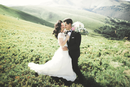 Beautiful wedding couple, bride and groom, in love on the background of mountainsの写真素材