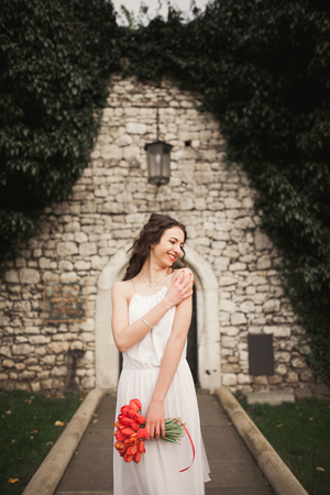 Bride. Beautiful young woman in the park with bouquet on a warm summer day.の写真素材
