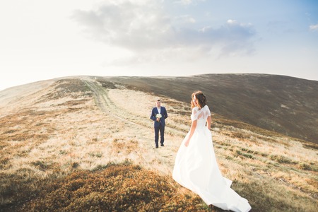 Beautifull wedding couple kissing and embracing near mountain with perfect viewの写真素材