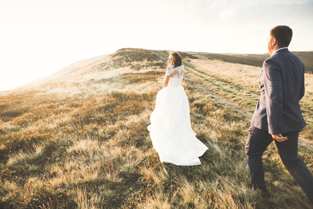 Beautiful gorgeous bride posing to groom and having fun, luxury ceremony at mountains with amazing view, space for text, wedding coupleの写真素材