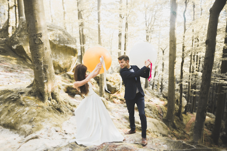 Young funny happy wedding couple outdoors with ballonsの写真素材