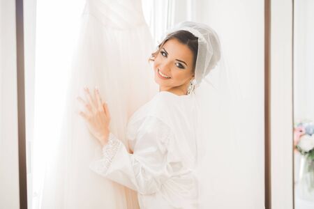 Luxury bride in white dress posing while preparing for the wedding ceremonyの写真素材