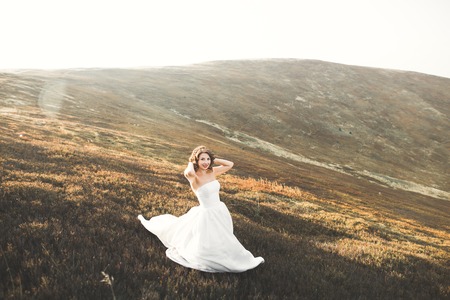 Beauty woman, bride with perfect white dress background mountainsの写真素材