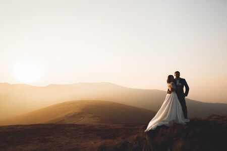 Beautiful gorgeous bride posing to groom and having fun, luxury ceremony at mountains with amazing view, space for text, wedding coupleの写真素材