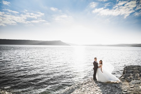 Happy wedding couple staying over beautiful landscapeの写真素材