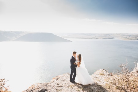 Happy and romantic scene of just married young wedding couple posing on beautiful beachの写真素材