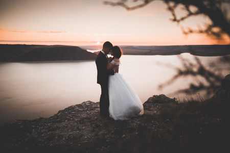 Happy wedding couple staying over beautiful landscapeの写真素材