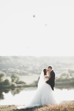 Newly married couple running and jumping in park while holding handsの写真素材