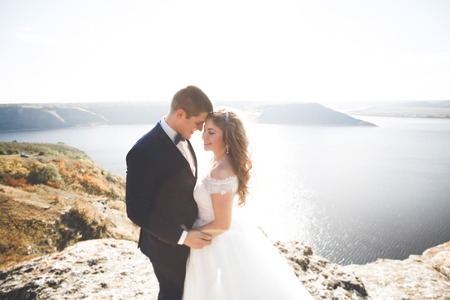 Happy and romantic scene of just married young wedding couple posing on beautiful beachの写真素材
