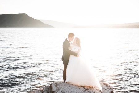 Happy wedding couple staying over beautiful landscapeの写真素材