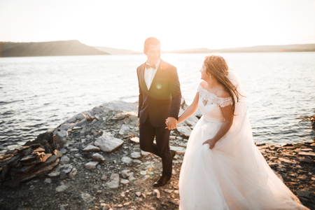 Happy and romantic scene of just married young wedding couple posing on beautiful beachの写真素材