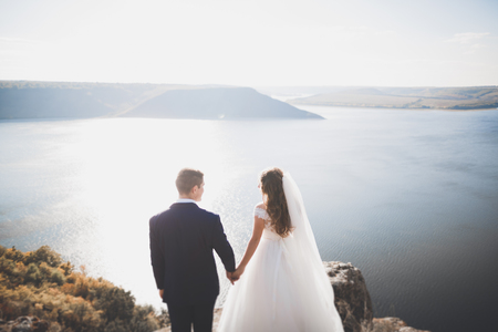 Happy and romantic scene of just married young wedding couple posing on beautiful beachの写真素材