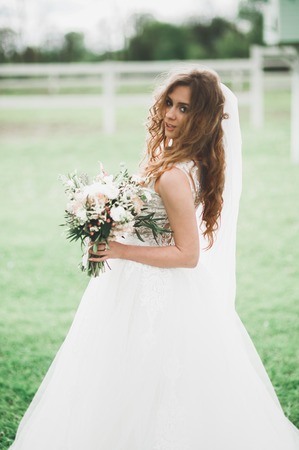 Portrait of stunning bride with long hair posing with great bouquet