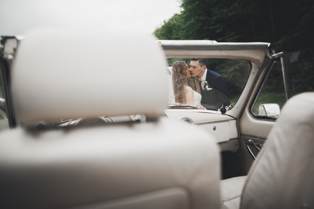 Just married couple in the luxury retro car on their wedding dayの写真素材
