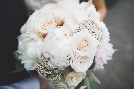 Bride holding big and beautiful wedding bouquet with flowersの写真素材