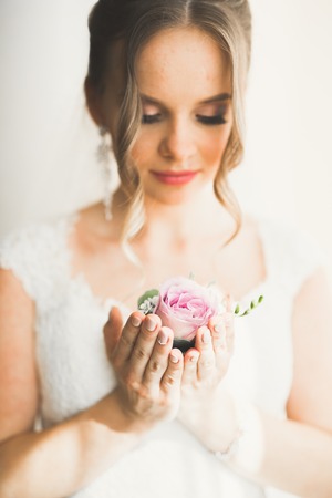 Beautiful bride wearing fashion wedding dress with feathers with luxury delight make-up and hairstyle, studio indoor photo shootの写真素材