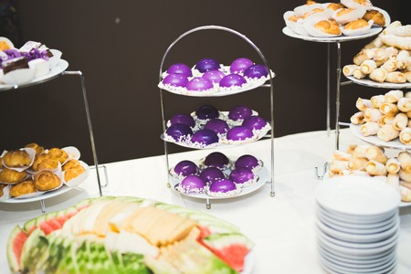 Delicious and tasty dessert table with cupcakes shots at reception closeup