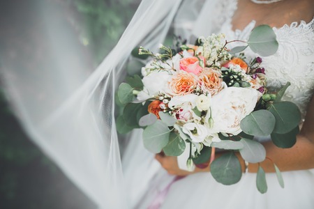 Bride holding big and beautiful wedding bouquet with flowersの写真素材