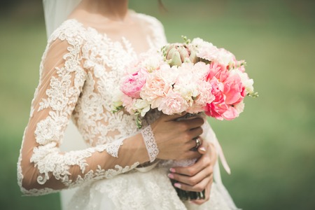 Bride holding big and beautiful wedding bouquet with flowersの写真素材