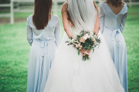 The bride and bridesmaids are showing beautiful flowers on their handsの写真素材