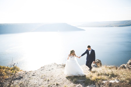 Happy wedding couple staying over beautiful landscapeの写真素材