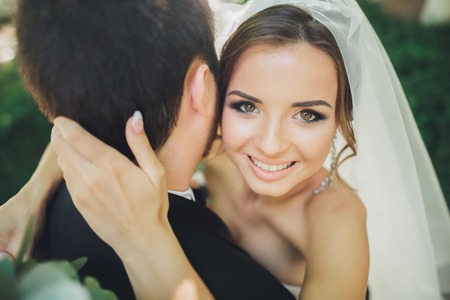 Stylish beautiful couple of happy newlyweds on their wedding day, close up portraitの写真素材