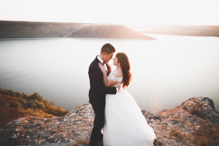 Happy wedding couple staying over beautiful landscapeの写真素材